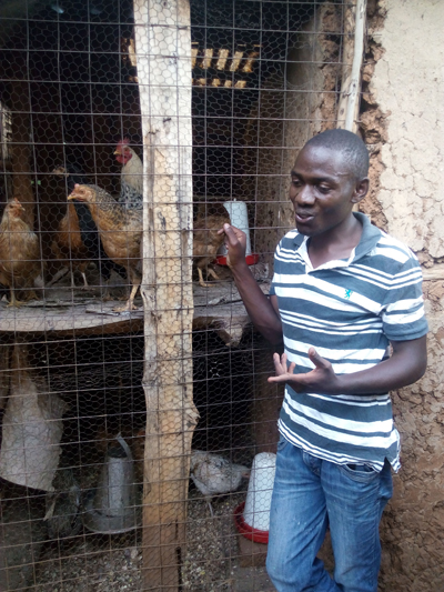 Evans, Youth representative of Itumbu sub-location in front of the communal chicken shelter, Itumbu sub-location. Credit: Bioversity International/I. Otieno