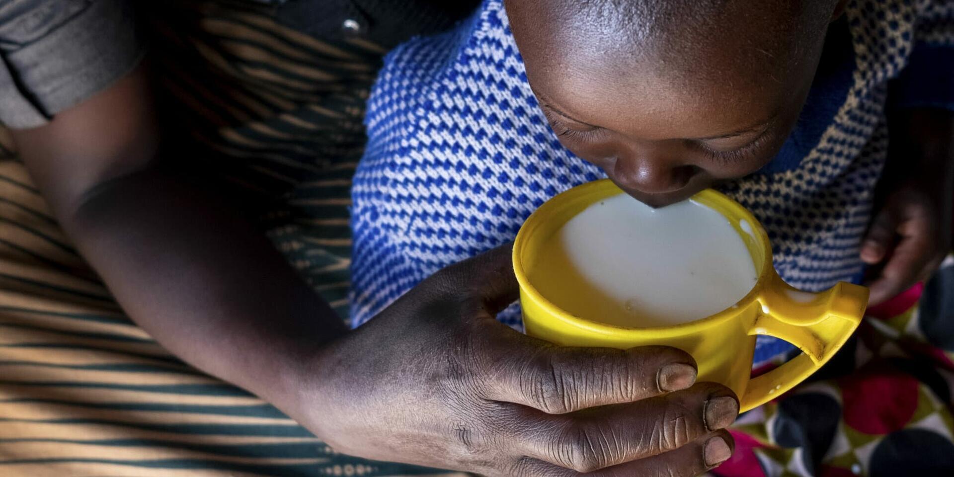 Una madre le da leche hervida a su hija en la aldea de Karucuranya, distrito de Nyabihu, en Ruanda.