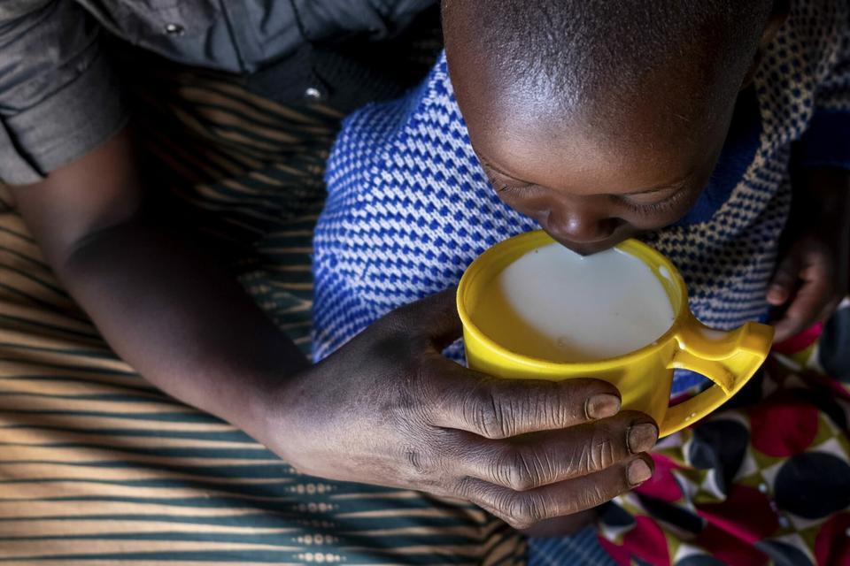 Una madre le da leche hervida a su hija en la aldea de Karucuranya, distrito de Nyabihu, en Ruanda.